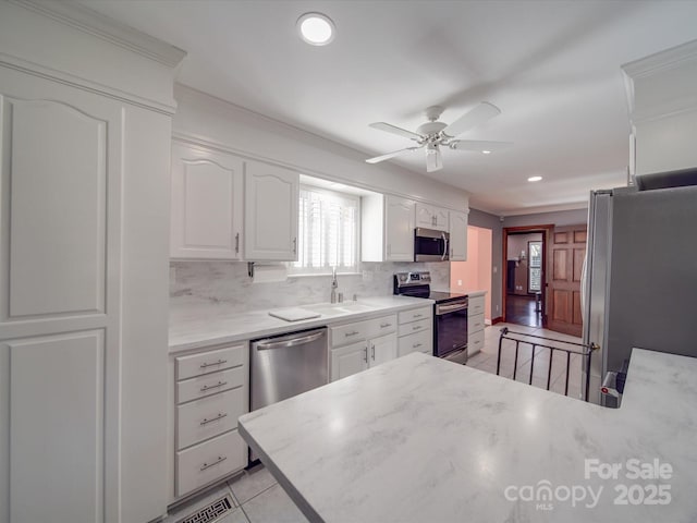 kitchen with light tile patterned flooring, sink, white cabinetry, stainless steel appliances, and decorative backsplash