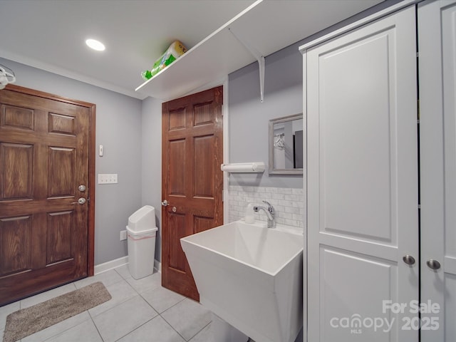 bathroom featuring tile patterned flooring, sink, and tasteful backsplash