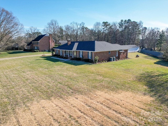 exterior space featuring central AC unit and a yard