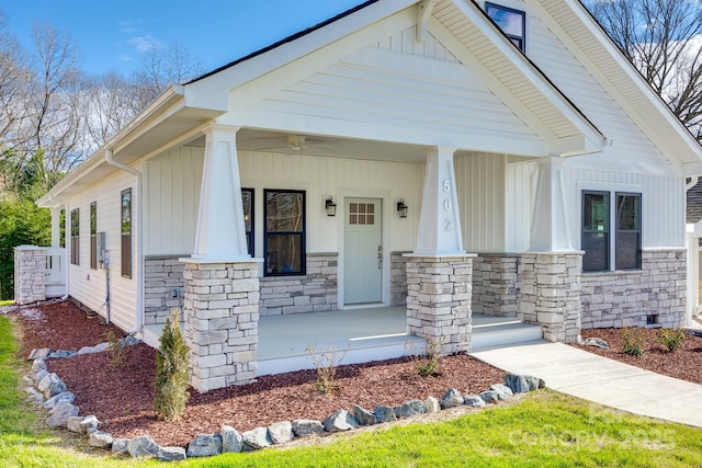 view of front of home featuring stone siding, a porch, and board and batten siding