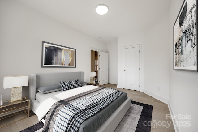 bedroom featuring baseboards and wood finished floors