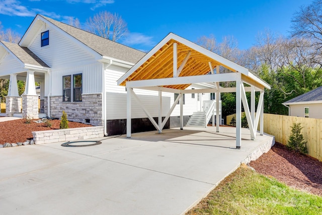 view of patio / terrace featuring a detached carport and fence