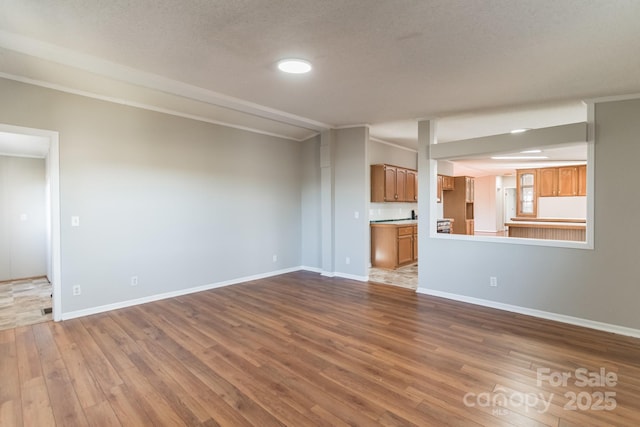 unfurnished living room with crown molding and wood-type flooring