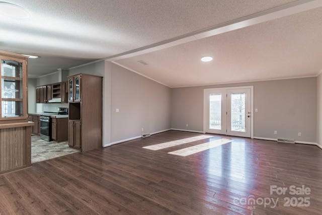 unfurnished living room with lofted ceiling, a textured ceiling, crown molding, and dark wood-type flooring