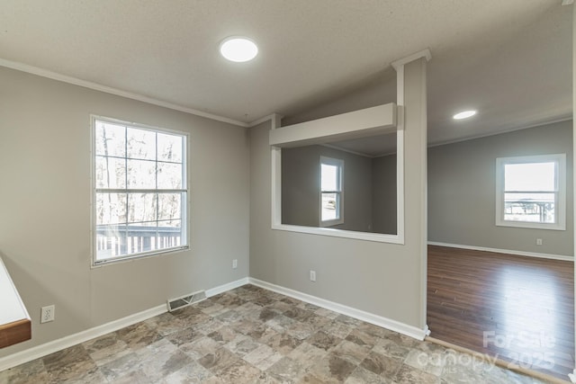 unfurnished room featuring a wealth of natural light, vaulted ceiling, and ornamental molding