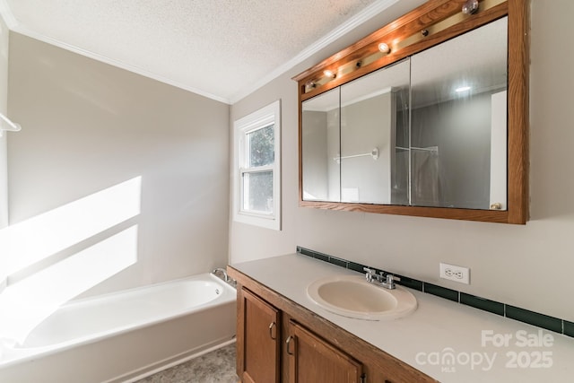 bathroom with ornamental molding, a textured ceiling, a bath, and vanity