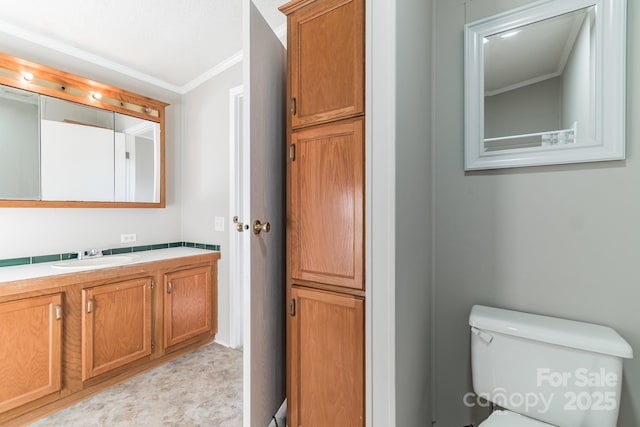 bathroom featuring ornamental molding, vanity, and toilet