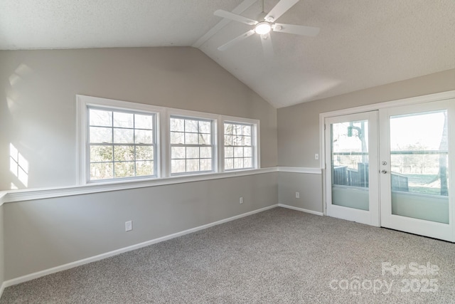 spare room with a textured ceiling, french doors, lofted ceiling, carpet floors, and ceiling fan