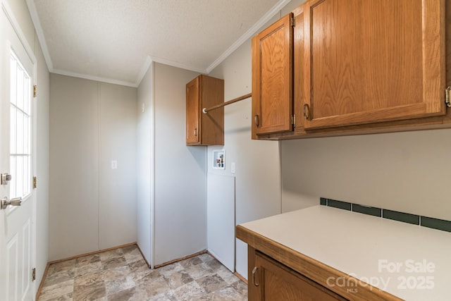 clothes washing area with washer hookup, ornamental molding, and cabinets