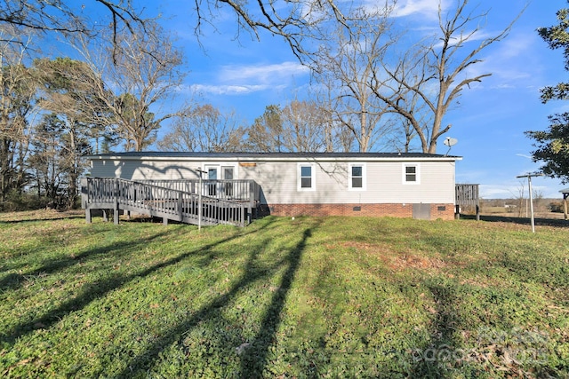 rear view of house with a deck and a lawn