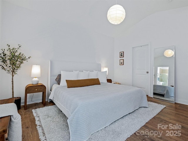 bedroom featuring vaulted ceiling and dark hardwood / wood-style floors