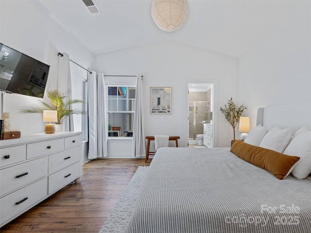 bedroom featuring ensuite bathroom, dark wood-type flooring, and lofted ceiling