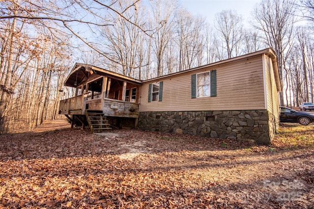 rear view of property featuring a wooden deck