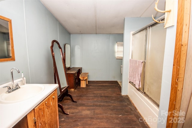 bathroom with combined bath / shower with glass door, vanity, and hardwood / wood-style flooring