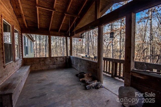 unfurnished sunroom featuring wooden ceiling and vaulted ceiling with beams