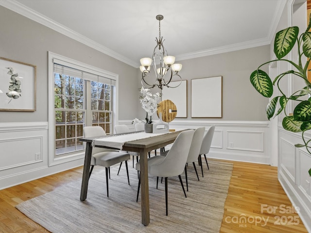 dining area featuring an inviting chandelier, ornamental molding, and light hardwood / wood-style floors