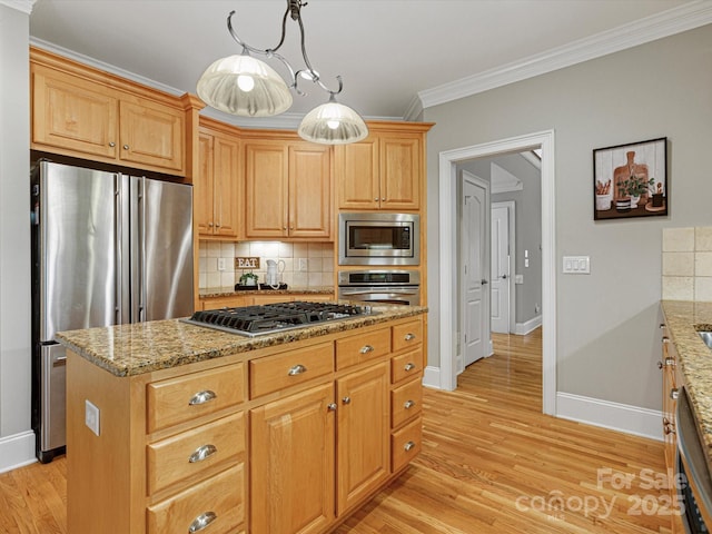 kitchen with stainless steel appliances, a kitchen island, ornamental molding, pendant lighting, and light stone counters