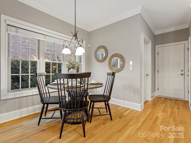 dining space featuring ornamental molding, hardwood / wood-style flooring, and a notable chandelier