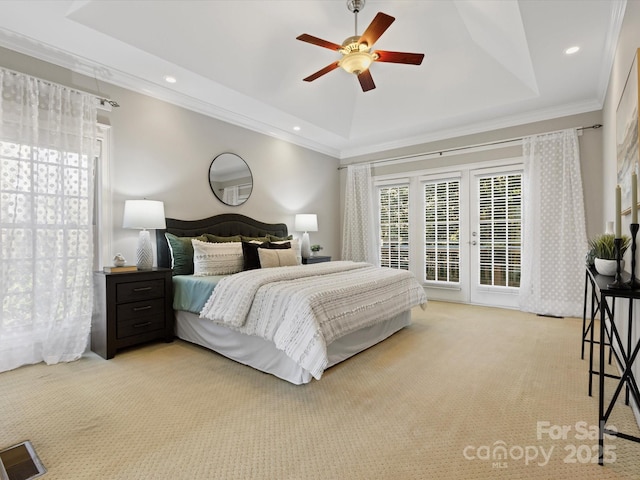 carpeted bedroom featuring ceiling fan, a tray ceiling, and ornamental molding