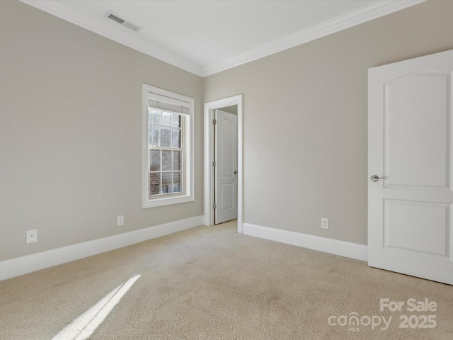 spare room featuring light carpet and crown molding