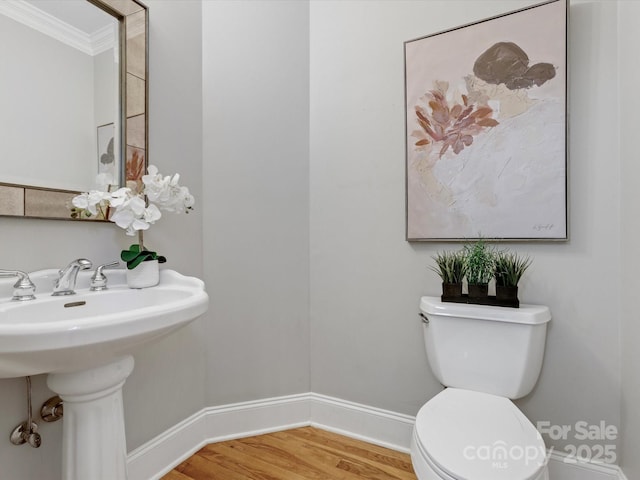 bathroom featuring toilet, crown molding, hardwood / wood-style floors, and sink