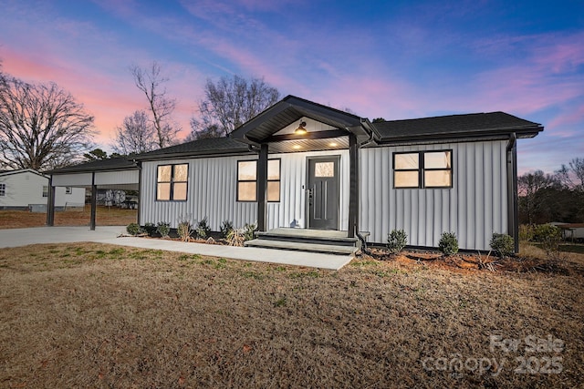 view of front of home featuring a carport and a yard