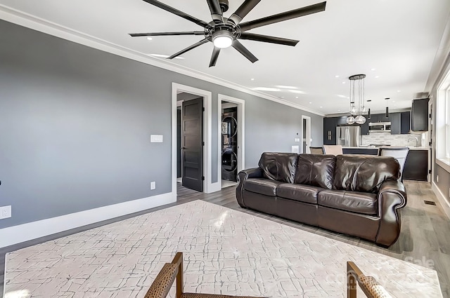 living room with ceiling fan, crown molding, and light hardwood / wood-style floors