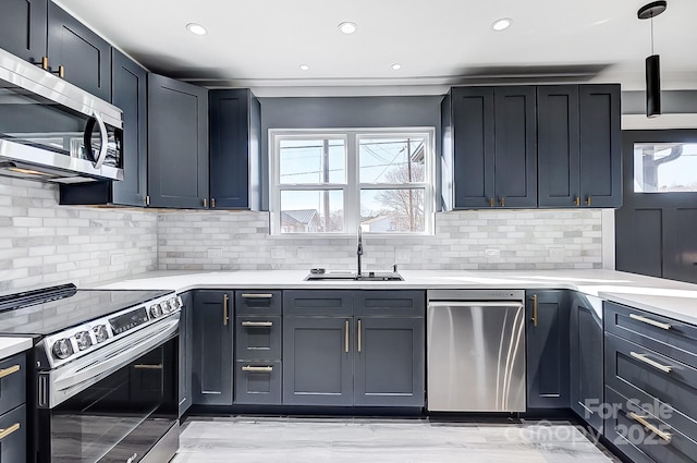 kitchen with appliances with stainless steel finishes, decorative backsplash, hanging light fixtures, and sink