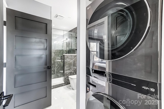 laundry area with stacked washer and dryer