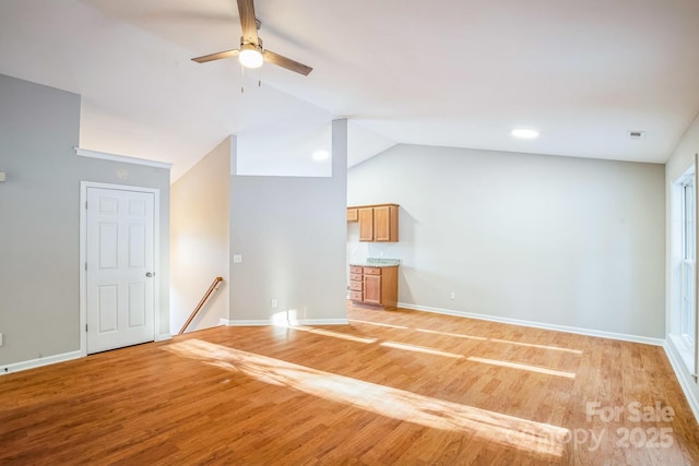 unfurnished living room featuring lofted ceiling, ceiling fan, and light hardwood / wood-style flooring