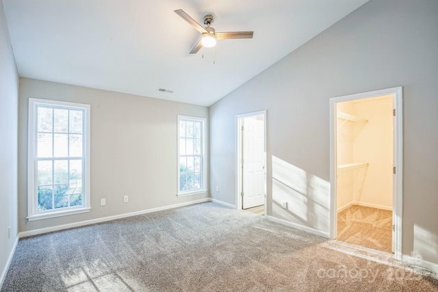 carpeted spare room featuring lofted ceiling and ceiling fan