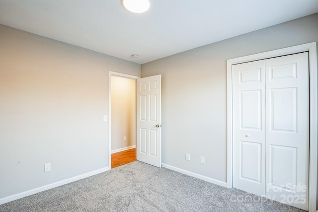 unfurnished bedroom with a closet and light carpet