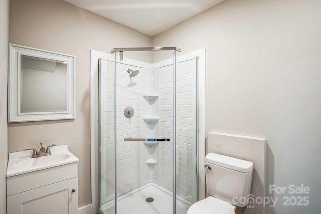 bathroom with toilet, a shower with door, and vanity