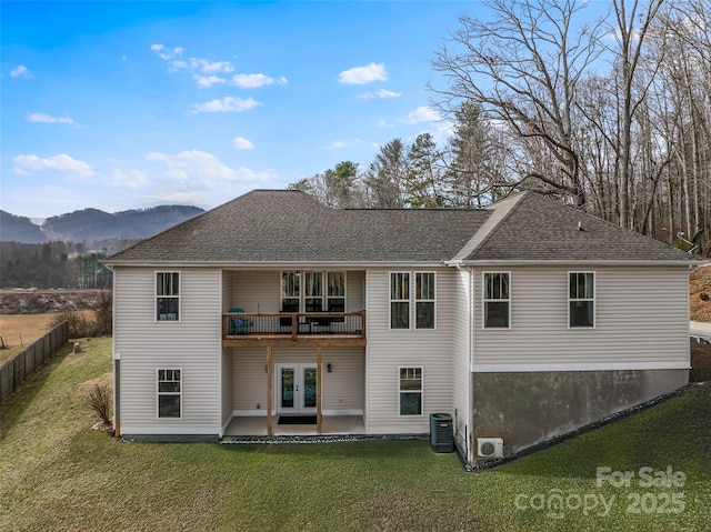 rear view of house with a mountain view, a yard, central AC unit, french doors, and a patio