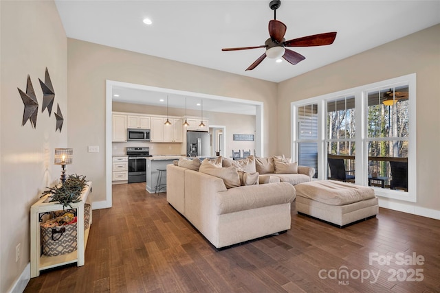 living room featuring ceiling fan and dark wood-type flooring