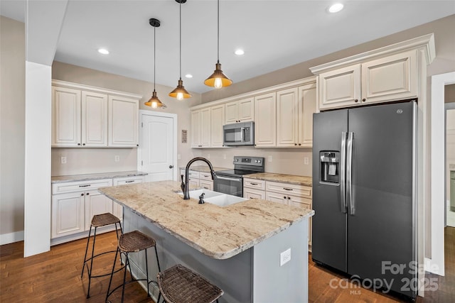 kitchen featuring sink, white cabinetry, a kitchen island with sink, stainless steel appliances, and light stone counters