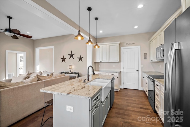 kitchen with decorative light fixtures, white cabinets, appliances with stainless steel finishes, and sink