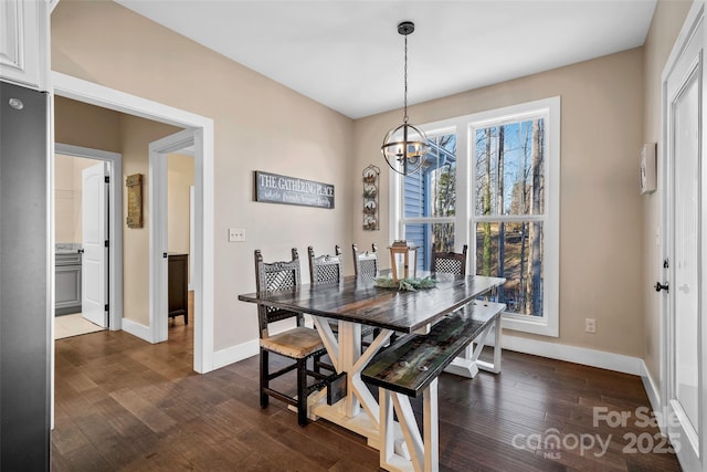 dining space with dark wood-type flooring and a notable chandelier