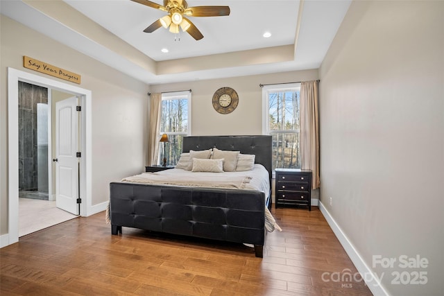 bedroom featuring ceiling fan and a tray ceiling