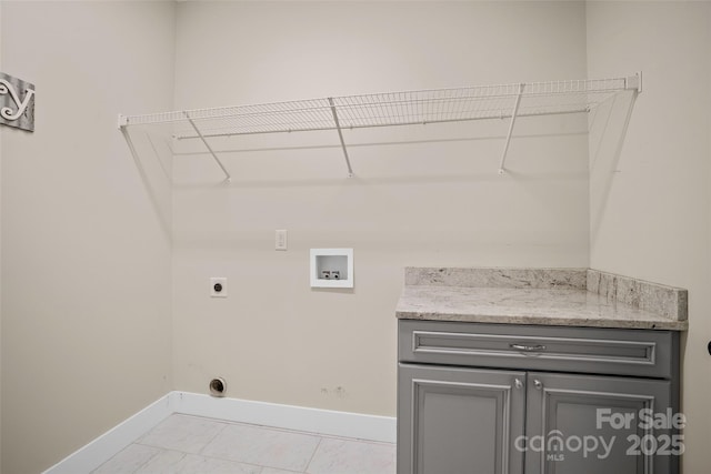 laundry room featuring light tile patterned floors, washer hookup, electric dryer hookup, and cabinets