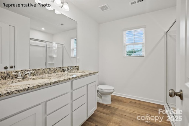 bathroom with toilet, an enclosed shower, vanity, and wood-type flooring