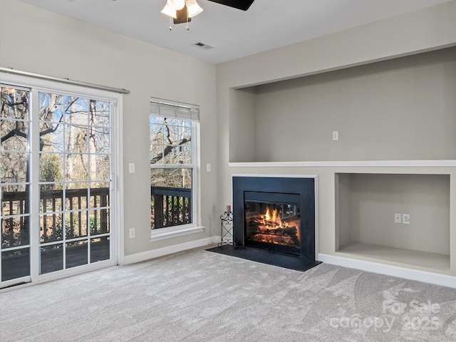 unfurnished living room with ceiling fan and carpet