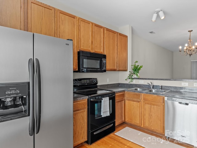 kitchen with sink, decorative light fixtures, a chandelier, light hardwood / wood-style flooring, and black appliances