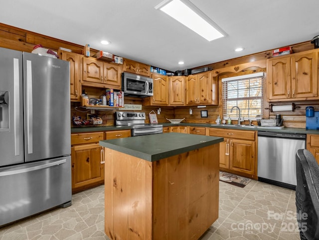 kitchen featuring appliances with stainless steel finishes, a center island, and sink