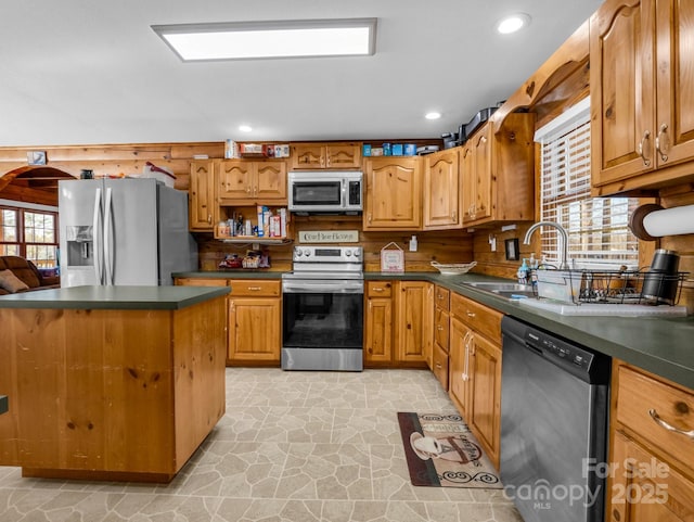 kitchen with appliances with stainless steel finishes, a center island, and sink