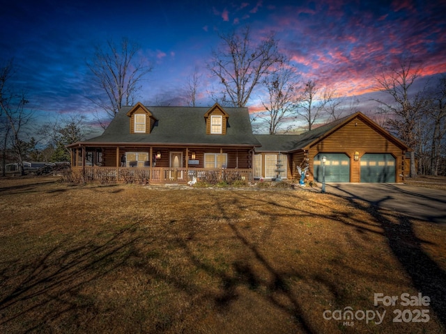 view of front of house featuring a garage, a yard, and covered porch