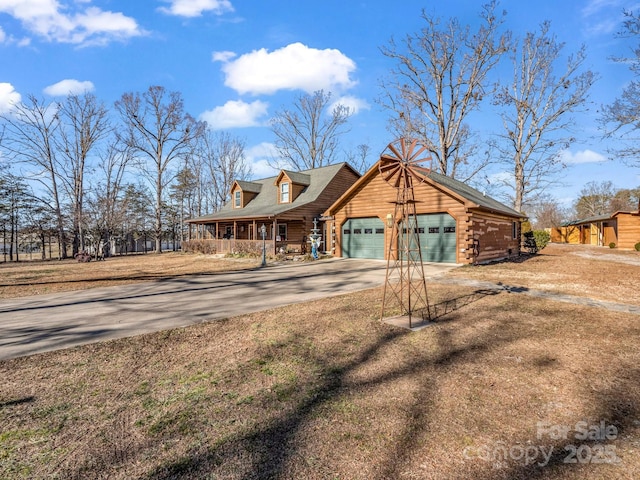 log home featuring a garage and covered porch