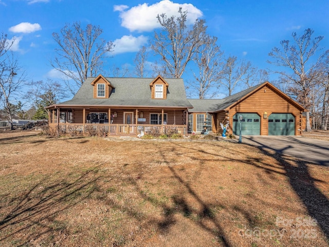 view of front of home featuring a garage, a front yard, and a porch