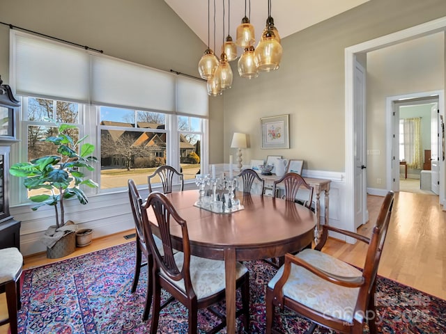 dining area featuring light hardwood / wood-style flooring and vaulted ceiling