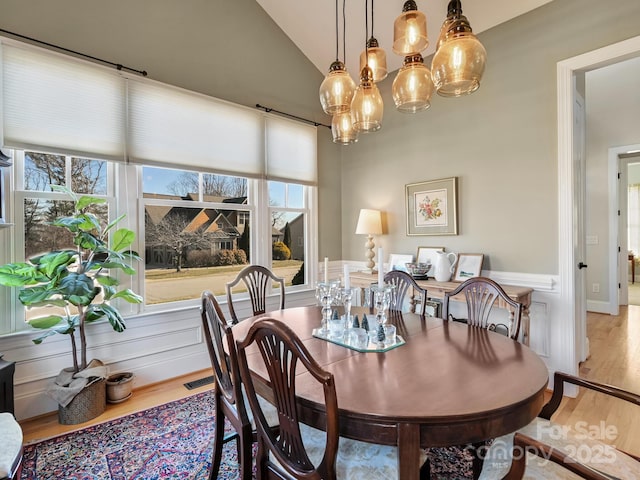 dining area with vaulted ceiling and hardwood / wood-style floors